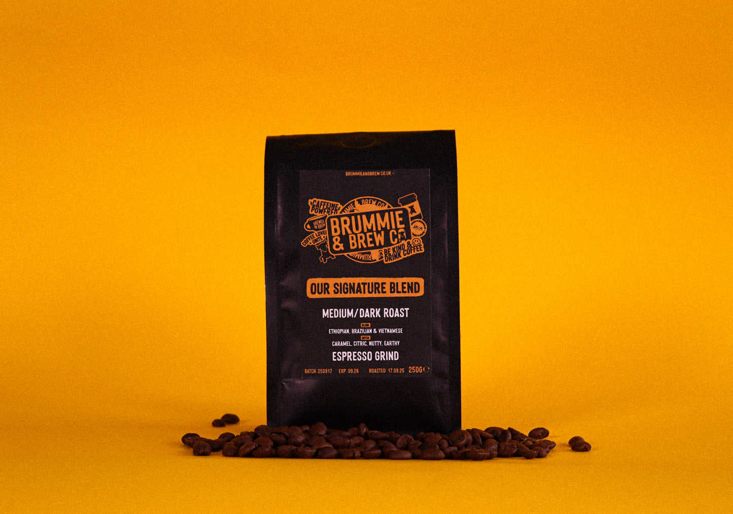 Coffee bag with branding on a yellow background surrounded by coffee beans at the bottom